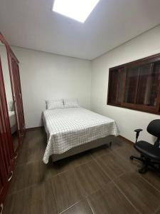 新汉堡市Casa Liberdade的一间卧室配有一张床和一把椅子