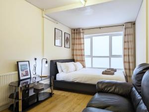 利物浦Guest Rooms Near City Centre & Dock Free Parking的一间卧室配有一张床、一张沙发和一个窗口
