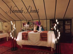 梅尔祖卡Nomada Domes的帐篷里的桌子,上面有蜡烛和标志