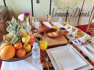梅尔祖卡Nomada Domes的一张桌子,上面放着一盘水果和果汁