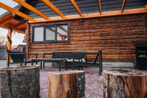 锡比乌Little Bear Lodge的小木屋设有2张长椅和2张木柴