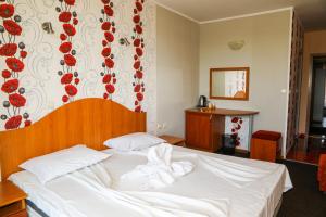 阳光海滩Family hotel Deykin的一间卧室配有带毛巾的床