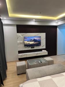 勒克瑙Grand DLF Stays的客厅设有壁挂式平面电视。