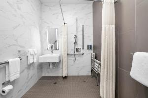 旧金山32万恩酒店的白色的浴室设有水槽和淋浴。