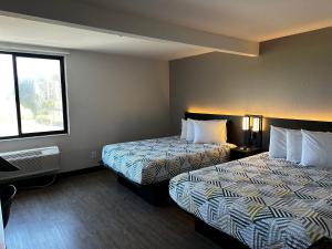 圣地亚哥圣地亚哥-酒店圈6号汽车旅馆的酒店客房设有两张床和窗户。