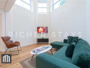 伦敦Exquisite 3BR Duplex Period Conversion, Air-con & Amenities的客厅配有蓝色的沙发和桌子