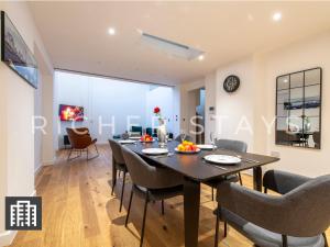 伦敦Exquisite 3BR Duplex Period Conversion, Air-con & Amenities的用餐室以及带桌椅的起居室。