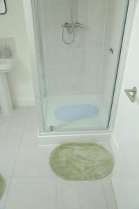 Cross GatesBeautiful New family home的白色的浴室设有地毯和淋浴