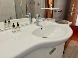 罗马Lucens Domus Appartamento Roma quartiere Trieste - vicino Metro b1 -的浴室设有白色水槽和镜子