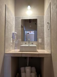 蒂尔卡拉Tierra Primitiva的浴室配有盥洗盆、镜子和毛巾