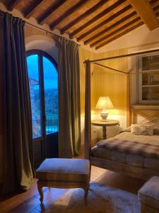 兰波雷基奥Il Borghetto Andrea Tafi的一间卧室配有一张床、一张桌子和一个窗户。