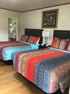 大派恩星光汽车旅馆的两张带色彩缤纷的毯子和枕头的床