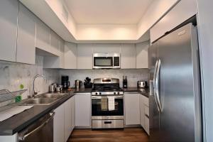 洛杉矶Los Angeles Premium 2BR&2BT Suites with Free Parking的厨房配有白色橱柜和不锈钢冰箱