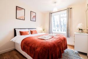 伦敦Fantastic 2 Bed London Apartment的一间卧室配有一张带红色毯子的床