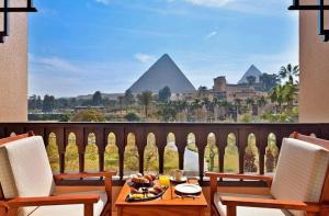 开罗Just A Break - جست بريك لحجز الفنادق的金字塔阳台上的一张桌子和一碗水果