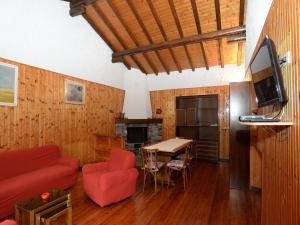 德尔维奥Annita Holiday Home的客厅配有红色的沙发和桌子