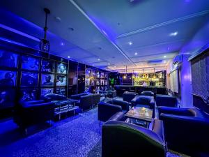 拉各斯Parkview Astoria Hotel的一间拥有蓝色灯光和沙发的房间和一间酒吧