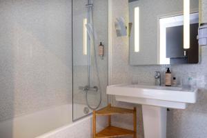 圣雅克德拉朗德Best Western Plus Hôtel Isidore的一间带水槽、淋浴和镜子的浴室