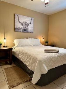 伊格尔帕斯Western Style - 2 bed/1 bath (RATED 10 STARS)的一间卧室,卧室里配有一张带公牛照片的床