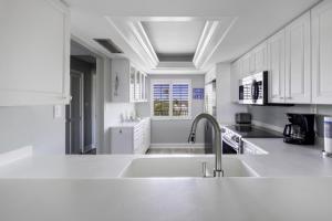 萨尼贝尔Loggerhead 314 condo的白色的厨房设有水槽和台面