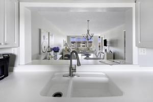 萨尼贝尔Loggerhead 314 condo的白色的厨房配有水槽和镜子
