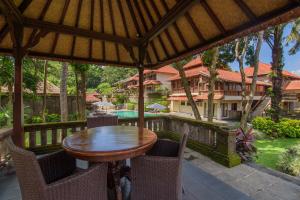 乌布Champlung Sari Hotel and Spa Ubud的户外庭院配有木桌和椅子