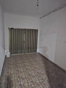 瓜鲁雅casa c/piscina enseada guaruja的一间空房间,铺有木地板,拥有白色的墙壁