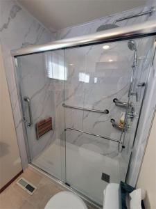 埃德蒙顿The Dewberry Homestay B&B的一间带卫生间的浴室内的玻璃淋浴间