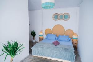 比拉Woywoy Paradise的一间卧室配有一张带蓝色枕头的床