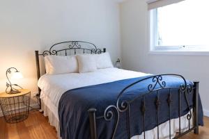 Upwey帕迪溪休闲度假屋的一间卧室配有一张带蓝色毯子的床和窗户。