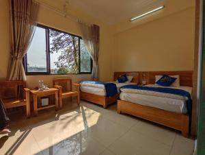 山萝Khách sạn Hoàng Sơn的一间卧室设有两张床和窗户。