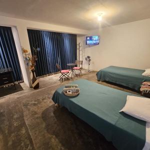 利马Lima Airport Hostel with FREE AIRPORT PICK UP的一间卧室设有两张床,墙上配有电视。