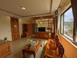 山萝Khách sạn Hoàng Sơn的客厅配有木桌和沙发