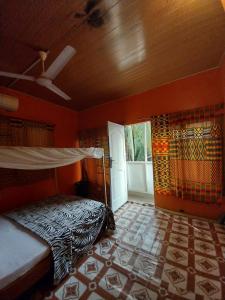 海岸角Orange Beach hostel的一间带床的卧室,位于带窗户的房间内