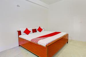 坎普尔OYO Flagship City Light Hotel的一张带红色和白色枕头的床