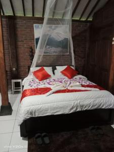 日惹Villa Mak Cik的一间卧室配有红色枕头的床