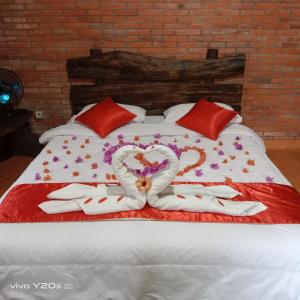 日惹Villa Mak Cik的一张带两个心和毛巾的床