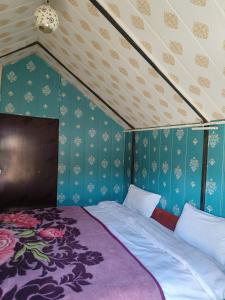 穆索里KASANA CLUB MUSSOORIE的一间设有床铺的卧室,位于一间拥有蓝色墙壁的房间