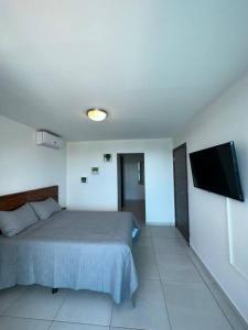 特古西加尔巴Luxury 2BR Apartment in Astria 605的一间卧室配有一张床和一台平面电视