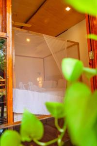 阿贡达Agonda Serenity Resort的一间卧室配有一张带天蓬的白色床