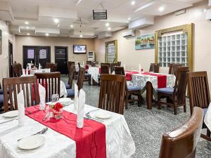 拉各斯Parkview Astoria Hotel的餐厅设有桌椅,配有红色和白色的桌布