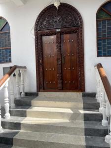 NgamboNashu House Stone Town的通往木门的楼梯