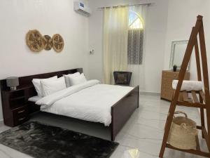 NgamboNashu House Stone Town的一间卧室配有一张带白色床单的床和一扇窗户。