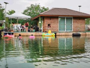 บ้านกลางโดม Baan Klang Dome的水面上的房子,水面上有船
