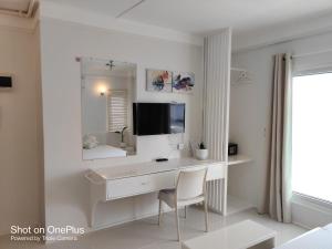长滩岛麦卡萨酒店的白色的浴室设有书桌和镜子