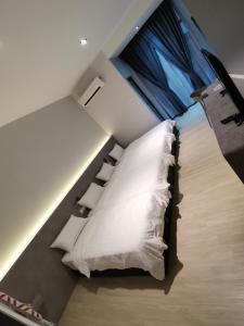 哥打巴鲁HOTEL SENTOSA KOTA BHARU Kelantan的客房配有带白色枕头的床。