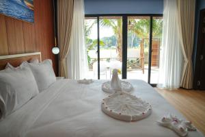 Phumĭ Kaôh Rŭng Sâmlœ̆m KhnŏngOne Beach Private Villa的卧室配有白色的床和鞋