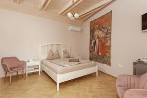 克韦什卡尔Köveskál Panzió的卧室配有一张床,墙上挂有绘画作品