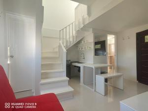 长滩岛麦卡萨酒店的白色的厨房设有楼梯和红色沙发