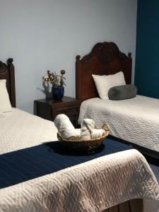 特克潘危地马拉Casa de los Abuelos Hotel的一间设有两张床的客房,床上配有一篮毛巾
